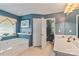 Bright blue bathroom with a soaking tub, white vanity, and view into an adjacent water closet at 4038 Forest Brook Dr, Edgemoor, SC 29712