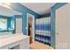 Bathroom featuring blue walls, a vanity with white drawers, and a shower with a blue striped curtain at 4038 Forest Brook Dr, Edgemoor, SC 29712
