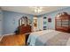 Bedroom featuring hardwood floors, blue walls, and a classic wooden dresser with an ornate mirror at 4038 Forest Brook Dr, Edgemoor, SC 29712