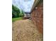 View of the backyard featuring a brick home and back porch with small brown rocks at 409 S Martin Luther King Jr Ave, Salisbury, NC 28144