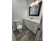 Bathroom featuring a toilet, vanity with drawers, mirror and wood-look laminate flooring at 409 S Martin Luther King Jr Ave, Salisbury, NC 28144