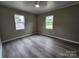 Bedroom featuring a ceiling fan, two windows, fresh paint, and wood-look laminate flooring at 409 S Martin Luther King Jr Ave, Salisbury, NC 28144