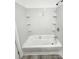Bathroom shower and bathtub featuring white tile surround and shelves at 409 S Martin Luther King Jr Ave, Salisbury, NC 28144