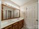 Bright bathroom features a double sink vanity, large mirror, and storage in the linen closet at 4509 Rosecliff Dr, Charlotte, NC 28277