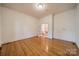 Spacious bedroom featuring hardwood flooring, white walls, and an open doorway leading to another room at 4509 Rosecliff Dr, Charlotte, NC 28277