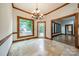 Bright dining area with stone floors, wooden trim, chandelier, and large picture window to the backyard at 4509 Rosecliff Dr, Charlotte, NC 28277