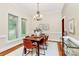 Formal dining room with natural light, a wooden table with seating for six, a chandelier, and hardwood floors at 4509 Rosecliff Dr, Charlotte, NC 28277