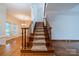 Open entryway featuring hardwood floors, staircase with carpet runner, iron spindles, and a view into the dining area at 4509 Rosecliff Dr, Charlotte, NC 28277