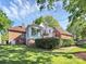Beautiful home showcasing brick and white siding, a sunroom, and a well-manicured lawn with mature trees at 4509 Rosecliff Dr, Charlotte, NC 28277