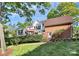 Exterior home view featuring a brick facade, sunroom, and a well-maintained lawn with mature trees at 4509 Rosecliff Dr, Charlotte, NC 28277