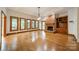 Open living room boasts hardwood floors, brick fireplace, and ample natural light from large windows at 4509 Rosecliff Dr, Charlotte, NC 28277