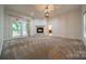 Carpeted living room with a fireplace, white trim, neutral paint, and glass doors to the outside at 4509 Rosecliff Dr, Charlotte, NC 28277