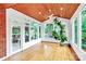 Sunroom featuring hardwood floors, wood ceiling, multiple windows, and view of yard at 4509 Rosecliff Dr, Charlotte, NC 28277