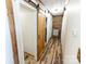 Hallway boasts wood-look flooring and a barn door at 5014 Oxford School Rd, Claremont, NC 28610