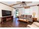 Cozy living room with hardwood floors, exposed beams, a decorative ceiling fan, and a bright front entry at 5014 Oxford School Rd, Claremont, NC 28610