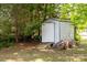 Outdoor shed provides extra storage space on the property, surrounded by trees at 5014 Oxford School Rd, Claremont, NC 28610