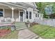 Home's entryway featuring traditional porch, colorful landscaping, and white picket fence at 531 Walnut St, Statesville, NC 28677