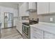 Modern kitchen featuring stainless steel appliances, white cabinetry, and wood floors at 531 Walnut St, Statesville, NC 28677