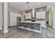 Open kitchen with island, stainless steel appliances, and wood floors at 531 Walnut St, Statesville, NC 28677