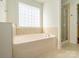 A bathtub in a luxurious bathroom with a tiled shower and glass block window at 541 Jetton St, Davidson, NC 28036