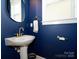 Stylish half bathroom featuring deep blue walls, updated sink and fixtures, and a modern design at 541 Jetton St, Davidson, NC 28036