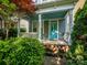 Inviting covered front porch with turquoise ceiling and front door, surrounded by manicured greenery at 541 Jetton St, Davidson, NC 28036