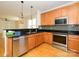 Open kitchen boasts hardwood floors, granite counters, stainless appliances, and bar seating at 541 Jetton St, Davidson, NC 28036