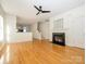 Open-concept living space with fireplace, ceiling fan, hardwood floors, and stairway at 541 Jetton St, Davidson, NC 28036