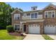 Charming townhome with stone accents, attached garages, manicured lawn, and inviting front entrance at 5621 Tipperlinn Way, Charlotte, NC 28278