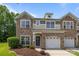 Charming townhome with stone accents, attached garages, manicured lawn, and inviting front entrance at 5621 Tipperlinn Way, Charlotte, NC 28278