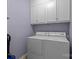 Functional laundry room equipped with washer, dryer, and overhead cabinets at 5621 Tipperlinn Way, Charlotte, NC 28278