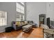 Cozy living space featuring tall ceilings, many windows, hardwood floors, and comfortable sectional at 5621 Tipperlinn Way, Charlotte, NC 28278