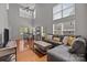 Spacious living room with hardwood floors, tall windows, comfortable seating, and dining space at 5621 Tipperlinn Way, Charlotte, NC 28278