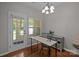 Bright office space, wood floors, white walls, natural light, table, chair, cabinet, and door to porch at 5621 Tipperlinn Way, Charlotte, NC 28278