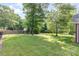Large backyard space with mature trees providing shade and green grass at 5706 Sustar Dr, Monroe, NC 28110