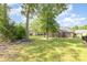 Large grassy backyard featuring mature trees and a fence surrounding the property at 5706 Sustar Dr, Monroe, NC 28110