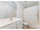 A bright bathroom includes a shower with a curtain, a mirror, and a tile floor at 5706 Sustar Dr, Monroe, NC 28110