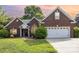 Charming brick home at sunset featuring a two-car garage and well-maintained lawn at 5706 Sustar Dr, Monroe, NC 28110