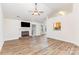 Bright living room with fireplace, TV, and hardwood floors, perfect for relaxation and entertaining at 5706 Sustar Dr, Monroe, NC 28110