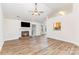 Bright living room with fireplace, TV, and hardwood floors, perfect for relaxation and entertaining at 5706 Sustar Dr, Monroe, NC 28110