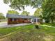 Brick home backyard with a sunroom, a concrete patio, and a well-kept lawn at 70 Cumberland Sw Ct, Concord, NC 28025