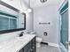 Bathroom featuring a marble vanity top, framed mirror, updated lighting, and shower with glass doors at 70 Cumberland Sw Ct, Concord, NC 28025