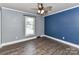 Bright bedroom featuring wood-look floors, a ceiling fan, and ample natural light from a large window at 70 Cumberland Sw Ct, Concord, NC 28025