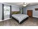 A bedroom featuring wood floors, windows, and a plaid bed with wooden headboard at 70 Cumberland Sw Ct, Concord, NC 28025