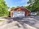 Side-entry garage with a white door and brick exterior, with parking pad at 70 Cumberland Sw Ct, Concord, NC 28025