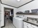 Spacious laundry room with appliances, storage shelves and sink, with view into a dining area at 70 Cumberland Sw Ct, Concord, NC 28025