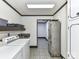 Functional laundry room with washer, dryer, utility sink, storage cabinets and an adjacent storage room at 70 Cumberland Sw Ct, Concord, NC 28025