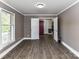 An open living room area with wood-look flooring, neutral-colored walls, and multiple doorways at 70 Cumberland Sw Ct, Concord, NC 28025