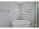 Bathroom featuring a freestanding tub with chrome hardware and a window with blinds at 7332 Newsome Sw Ct, Concord, NC 28025