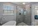 Bathroom featuring a glass shower and freestanding tub with a window for natural light at 7332 Newsome Sw Ct, Concord, NC 28025